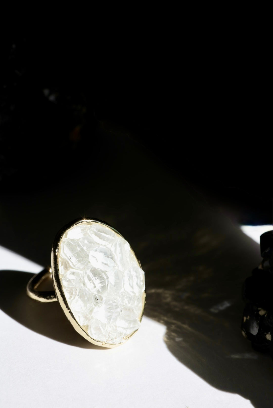 Gold ring with textured white herkimer diamond quartz stones on a dark background