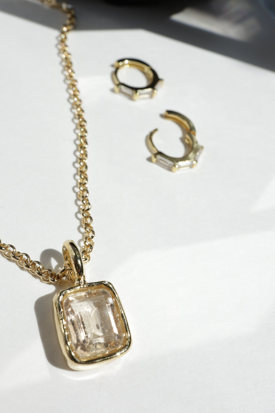 Gold jewelry set with earrings and a necklace on a white background